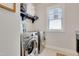 Modern laundry room with front loading washer and dryer, white cabinets, and a window at 100 Highveld Ave, Chapel Hill, NC 27516