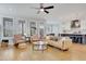 Bright living room featuring a modern ceiling fan, a brown leather sofa, and beautiful hardwood floors at 100 Highveld Ave, Chapel Hill, NC 27516