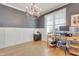 Well-lit home office with hardwood floors, a chandelier, gray accent wall, and a large window at 100 Highveld Ave, Chapel Hill, NC 27516