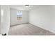 Bright bedroom featuring neutral tones, carpet flooring, and a window offering natural light at 105 S Mule Way # 89, Benson, NC 27504