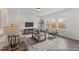 Bright living room featuring large windows, neutral furniture, wood accents, an area rug, and a television at 105 S Mule Way # 89, Benson, NC 27504