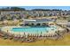 Large community pool with lounge chairs and a covered outdoor building surrounded by landscaping at 1095 Channel Drop Lp, Zebulon, NC 27597