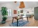 Open-concept dining room with hardwood floors and stylish lighting, open to kitchen and living room at 1112 Watauga Street St, Raleigh, NC 27604