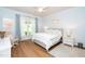 Calming bedroom features light blue walls, a ceiling fan, hardwood floors, and a large window at 112 Manning Way, Durham, NC 27703