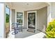 Inviting front porch featuring a charming chair, a glass table, and a decorated front door at 112 Manning Way, Durham, NC 27703