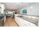 Open concept kitchen features white cabinets, granite counters, stainless steel appliances, and seamless transition to living spaces at 112 Manning Way, Durham, NC 27703