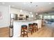 Kitchen bar area with stainless steel appliances, granite countertops, and pendant lighting overlooking the dining and living spaces at 112 Manning Way, Durham, NC 27703