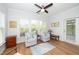 Cozy sunroom with a ceiling fan, hardwood floors, large windows, and access to an outdoor patio at 112 Manning Way, Durham, NC 27703