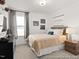 Bedroom showcasing neutral walls, a large window with curtains, and a bed with soft, comfortable bedding at 115 N District Ave # 298, Clayton, NC 27527