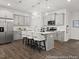 Modern kitchen featuring an island with seating, stainless steel appliances, pendant lighting and grey cabinets at 115 N District Ave # 298, Clayton, NC 27527