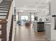 Open-concept living space with hardwood flooring, lots of natural light, kitchen island, and staircase at 115 N District Ave # 298, Clayton, NC 27527