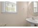 A clean powder room with a pedestal sink and a window with blinds at 1175 Contessa Dr, Cary, NC 27513