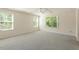Spacious bedroom with plush carpet, large windows, and a modern ceiling fan at 1175 Contessa Dr, Cary, NC 27513