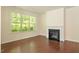 Cozy living room featuring hardwood floors, a fireplace, and natural light from a large window at 1175 Contessa Dr, Cary, NC 27513