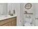 Cozy half bathroom with a light wood vanity and a decorative tree-themed wall hanging at 133 Pasadena Rd, Garner, NC 27529