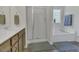 Bright bathroom featuring vanity with built-in sink, walk-in shower, and soaking tub at 133 Pasadena Rd, Garner, NC 27529