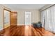 Well-lit bedroom with hardwood floors, neutral walls, and a view into an adjacent room at 1414 Walter Bright Rd, Sanford, NC 27330