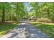 View of the long gravel driveway leading up to the home and attached garages at 1414 Walter Bright Rd, Sanford, NC 27330