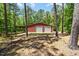 Exterior of the red outbuilding featuring two garage doors and an attached covered area at 1414 Walter Bright Rd, Sanford, NC 27330