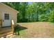A backyard featuring a door with stairs and a spacious grassy area surrounded by trees at 145 Mark St, Franklinton, NC 27525