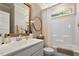 Clean bathroom featuring a single vanity, bathtub with shower, decorative mirror, and ample lighting at 1601 Glazebrook Dr, Wake Forest, NC 27587