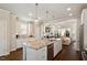 Bright open kitchen featuring a granite island, stainless steel appliances, and seamless flow into the living area at 1601 Glazebrook Dr, Wake Forest, NC 27587