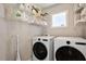 Efficient laundry room with modern washer, dryer, storage shelves, and a bright window at 1601 Glazebrook Dr, Wake Forest, NC 27587