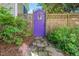 Charming backyard gate is painted purple and framed by plants at 1712 Briarforest Pl, Raleigh, NC 27615