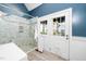 Bright bathroom showcasing a glass shower and a white door with charming pane windows at 1712 Briarforest Pl, Raleigh, NC 27615