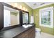 Bathroom boasts dual mirrors, a dark vanity, and a view of the window offering natural light at 1712 Briarforest Pl, Raleigh, NC 27615