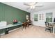 Spacious room with green accent wall, ceiling fan and multiple windows offering natural light at 1712 Briarforest Pl, Raleigh, NC 27615