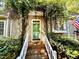 Inviting entrance with a green front door, brick steps, white railing and lush greenery at 1712 Briarforest Pl, Raleigh, NC 27615