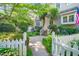 Charming home exterior featuring a welcoming entrance with lush greenery and a white picket fence at 1712 Briarforest Pl, Raleigh, NC 27615
