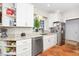 Bright kitchen with white cabinets, stainless steel appliances, and terra cotta tile flooring at 1712 Briarforest Pl, Raleigh, NC 27615