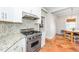 Well-lit kitchen features stainless steel appliances, granite countertops, and terracotta tile flooring at 1712 Briarforest Pl, Raleigh, NC 27615