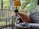Close up view of a sunroom with a comfortable couch, lamp, and glass of wine at 1712 Briarforest Pl, Raleigh, NC 27615