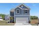 Charming two-story home boasts a blue exterior, white trim, and an attached two-car garage at 187 Curling Creek Dr # 298P, Clayton, NC 27527