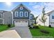 Charming two-story home featuring a two-car garage, manicured lawn, and a classic blue facade under a bright sky at 187 Curling Creek Dr # 298P, Clayton, NC 27527