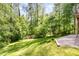 Backyard with green grass, woods, and a graveled area with a rock border at 200 Weybossett Rd, Henderson, NC 27537