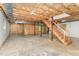 Unfinished basement with exposed ceiling, concrete floor, and stairs to main level at 200 Weybossett Rd, Henderson, NC 27537