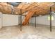 Unfinished basement with exposed ceiling, concrete floor, and stairs to main level at 200 Weybossett Rd, Henderson, NC 27537
