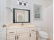 Bathroom featuring a large mirror, a vanity with storage, and a toilet, with a window bringing in natural light at 200 Weybossett Rd, Henderson, NC 27537