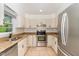 Well-lit kitchen featuring stainless steel appliances, granite countertops, and off-white cabinets at 200 Weybossett Rd, Henderson, NC 27537