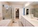 Bright bathroom with dual vanity, soaking tub, glass enclosed shower, and a walk-in closet at 201 Annabelle Blue Drive, Wake Forest, NC 27587