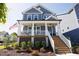 Charming home featuring a welcoming front porch, landscaped yard, and classic American flag display at 201 Annabelle Blue Drive, Wake Forest, NC 27587