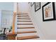 Elegant stairway features wood steps, white risers, and framed artwork, blending style with functionality at 201 Annabelle Blue Drive, Wake Forest, NC 27587