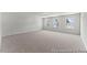 Spacious carpeted bedroom offers three bright windows providing natural light at 207 Curling Creek Dr # 300P, Clayton, NC 27527