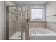 Clean bathroom featuring a glass-enclosed shower, soaking tub, and warm neutral tiling at 212 Crisp Rd, Durham, NC 27713