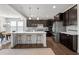 Modern kitchen with dark cabinets, a center island with bar stools, and stainless steel appliances at 212 Crisp Rd, Durham, NC 27713
