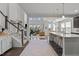 Open-concept living space with a kitchen island, staircase, and a view into the well-lit living room at 212 Crisp Rd, Durham, NC 27713
